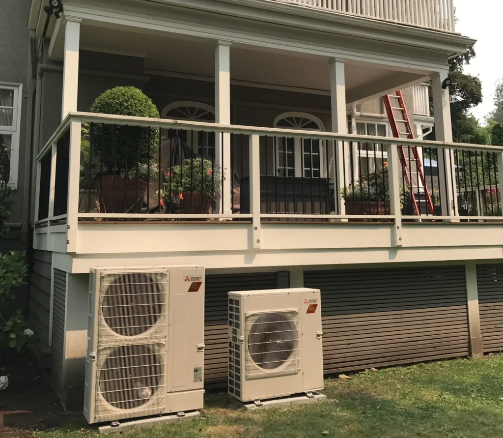 Multiple Mitsubishi outdoor HVAC units installed beneath residential deck